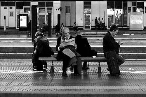 Four people giving their backs one another at Rogoredo railway station, Milan