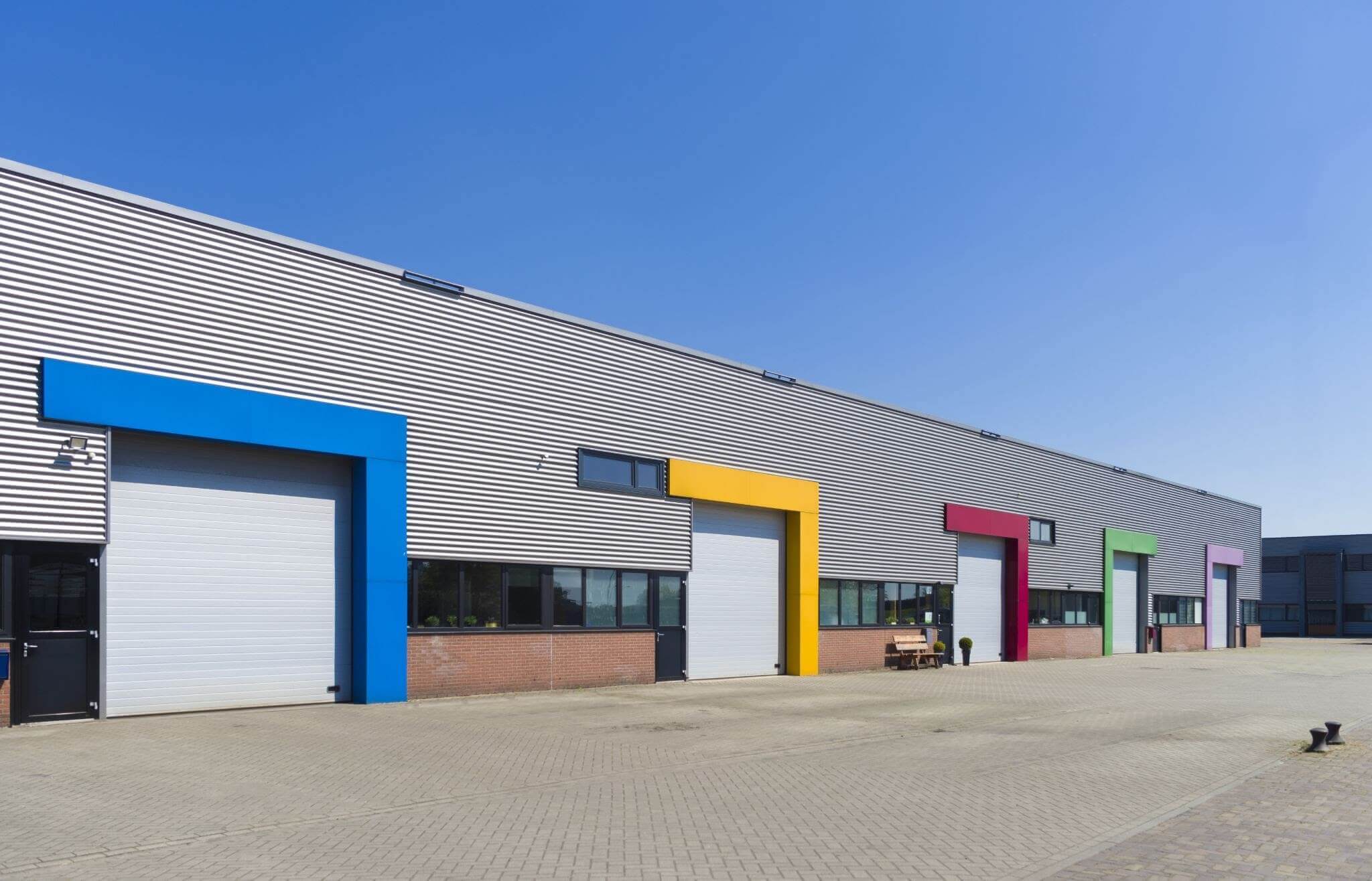 Metal building with three bays. One bay has a blue border around it.One bay has a yellow border around it.One bay has a red border around it.