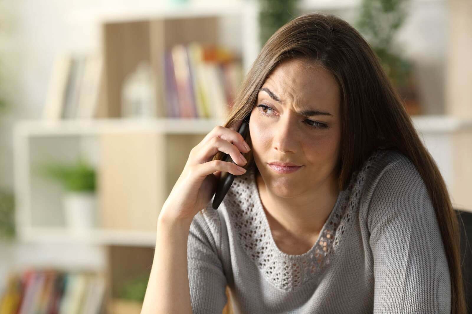 Woman on phone with a skeptical look on her face