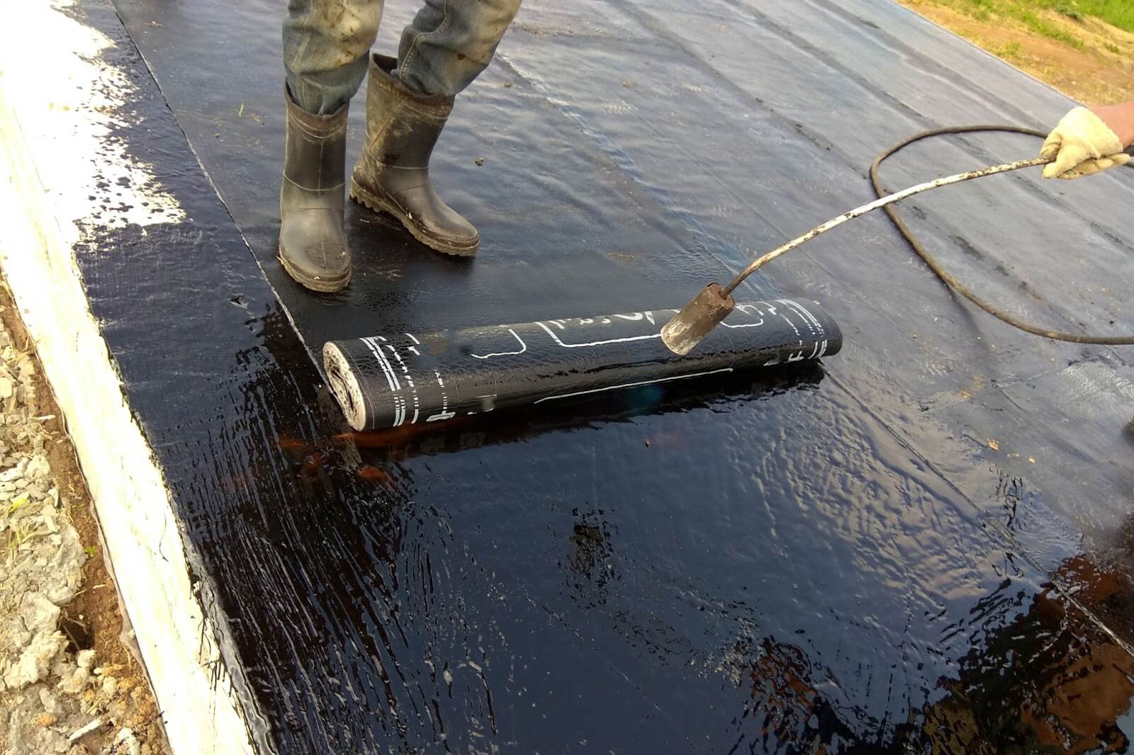 Professional applying commercial concrete sealant outdoors